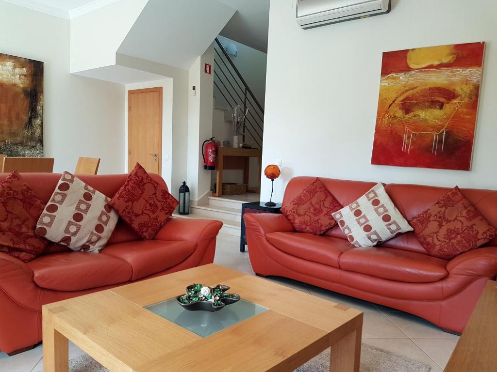 a living room with red couches and a coffee table at Balaia Residence in Albufeira