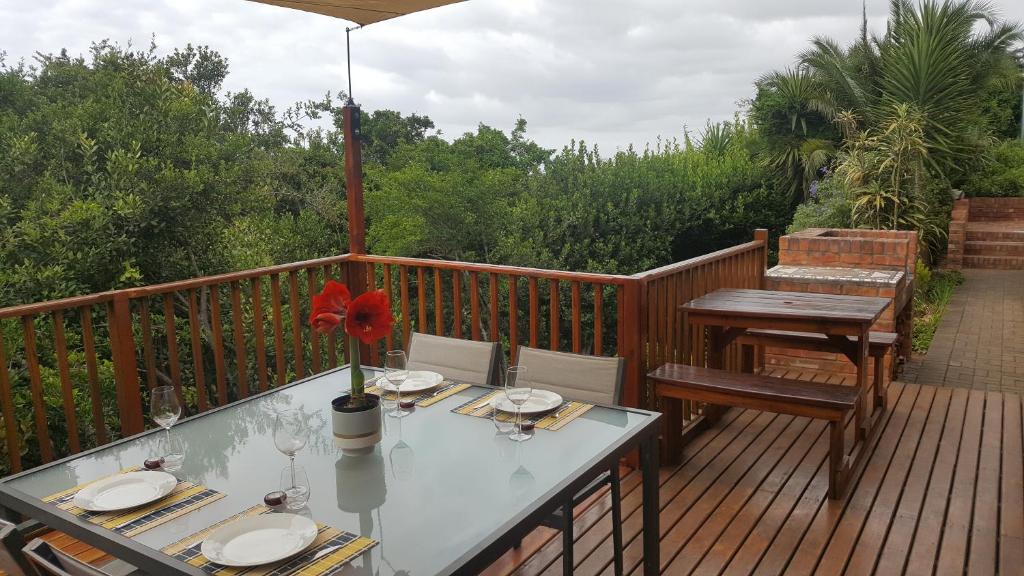 a wooden deck with a table and chairs on it at Lent@Grootbrak in Groot Brak Rivier