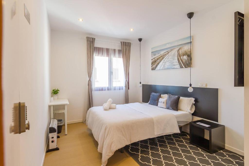 a bedroom with a large white bed and a window at AYZ Javier Cabrini - Auto check-in property in Madrid
