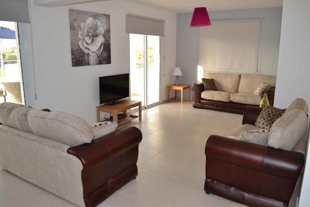 a living room with two couches and a television at Oceania Bay Village in Pyla