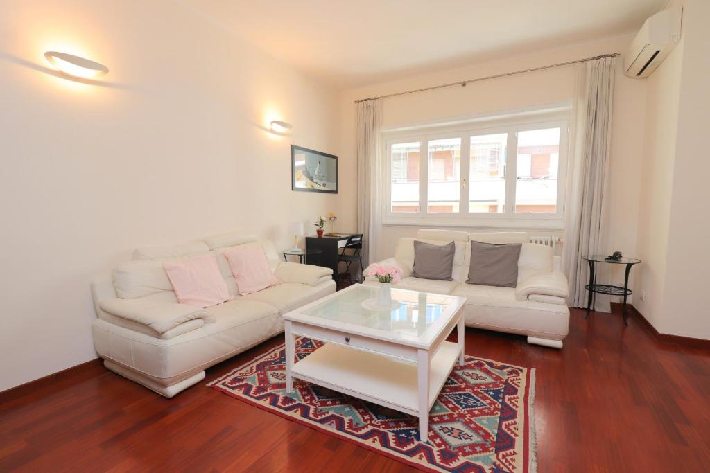 - un salon avec un canapé blanc et une table basse dans l'établissement St Peter new and lightsome apartment with balcony, à Rome