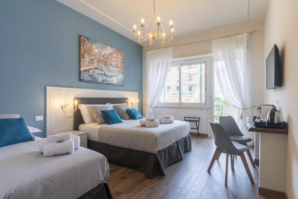 a bedroom with two beds with blue walls and a chandelier at Trastevere Gallery Suites in Rome