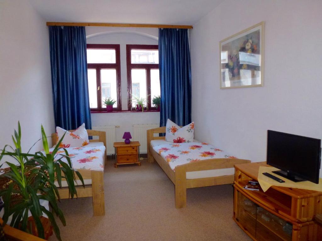 Habitación con 2 camas, TV y sofá. en Pension Bergmann-Welp en Freiberg