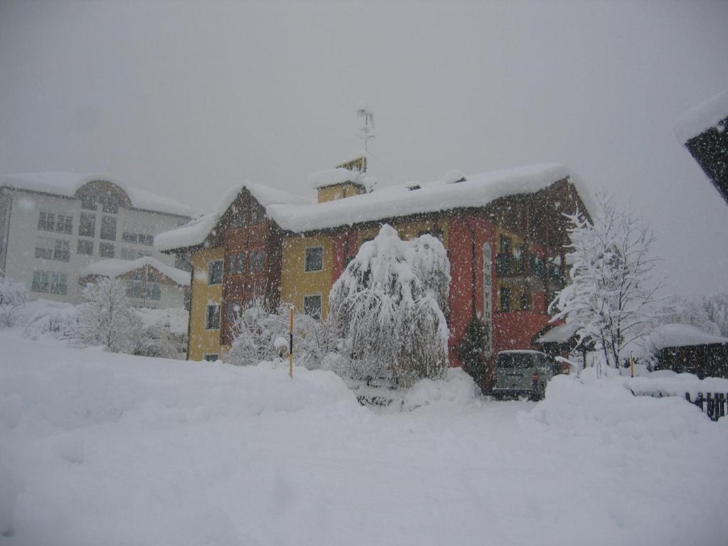 um edifício coberto de neve numa tempestade de neve em Animae Natura Hotel & Chalet em Mezzana