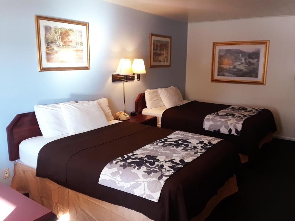 a hotel room with two beds with black and white sheets at The Budget Inn Express in Sheridan