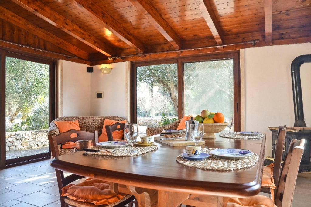 a dining room with a large wooden table with chairs at Villa Alessandra in Ceglie Messapica
