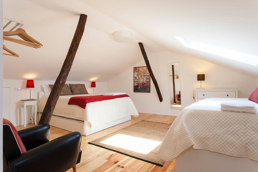 - une chambre mansardée avec 2 lits et une chaise dans l'établissement Merces by Central Hill Apartments, à Lisbonne