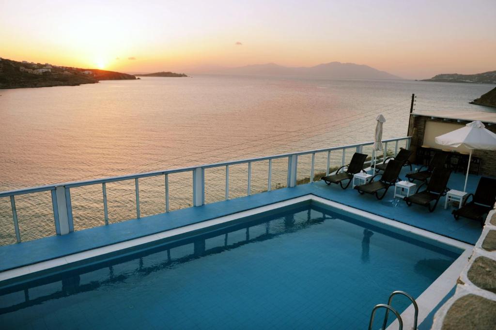 a swimming pool on the deck of a cruise ship with the sunset at Vana Holidays in Ornos