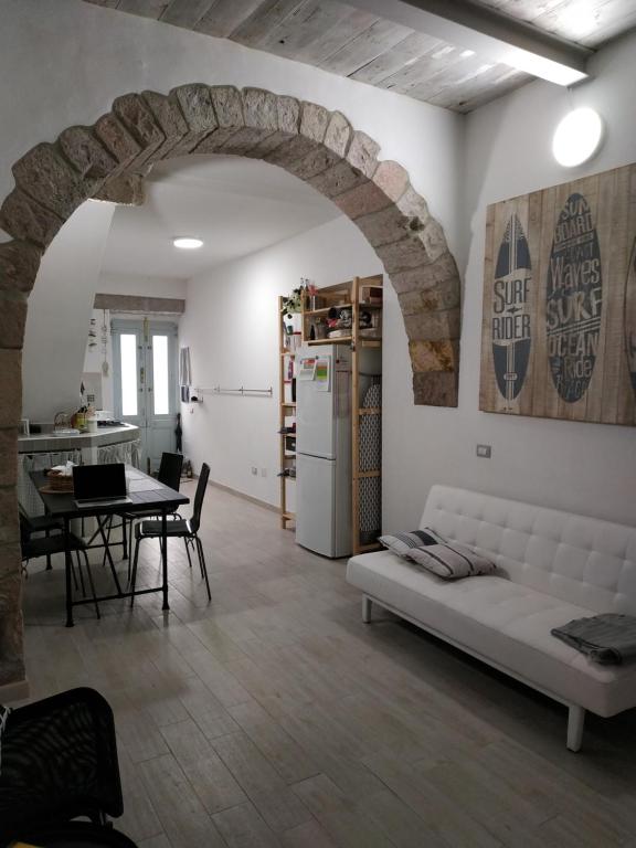 uma sala de estar com um sofá branco e uma mesa em A cà du Pellegrin em Carloforte