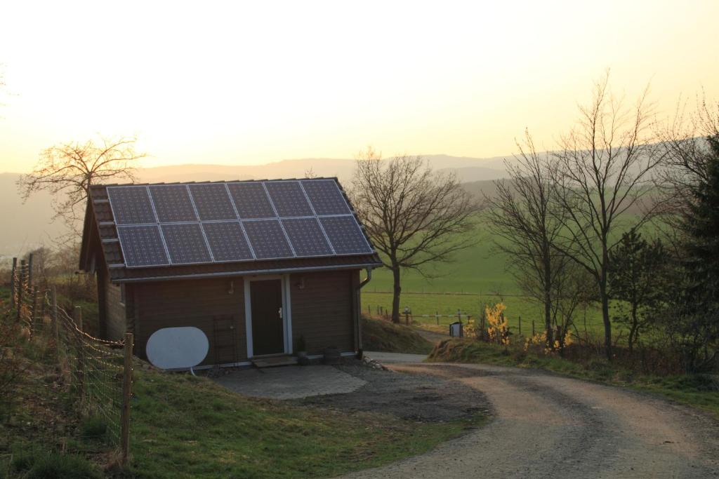 ein Haus mit Sonnenkollektoren an der Seite einer Straße in der Unterkunft Hof Marienberg, 56340 Osterspai, Deutschland Wanderhütte in Osterspai