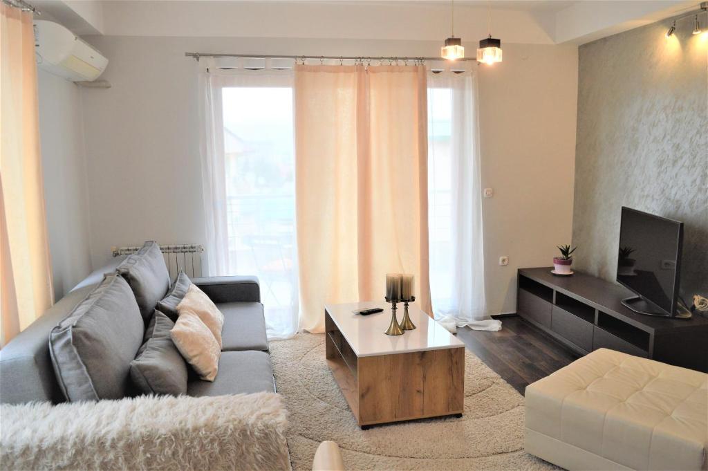 een woonkamer met een bank en een tv bij Antigona Apartments in Skopje