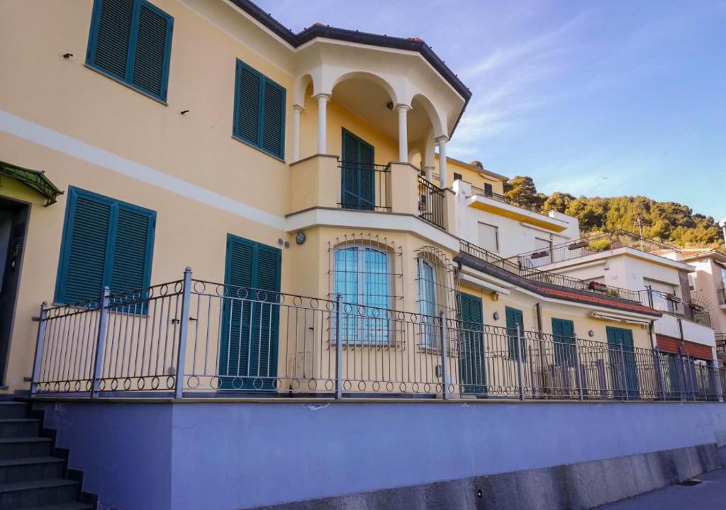 un edificio con persianas verdes y balcón en A Cà d'Assunta, en Laigueglia