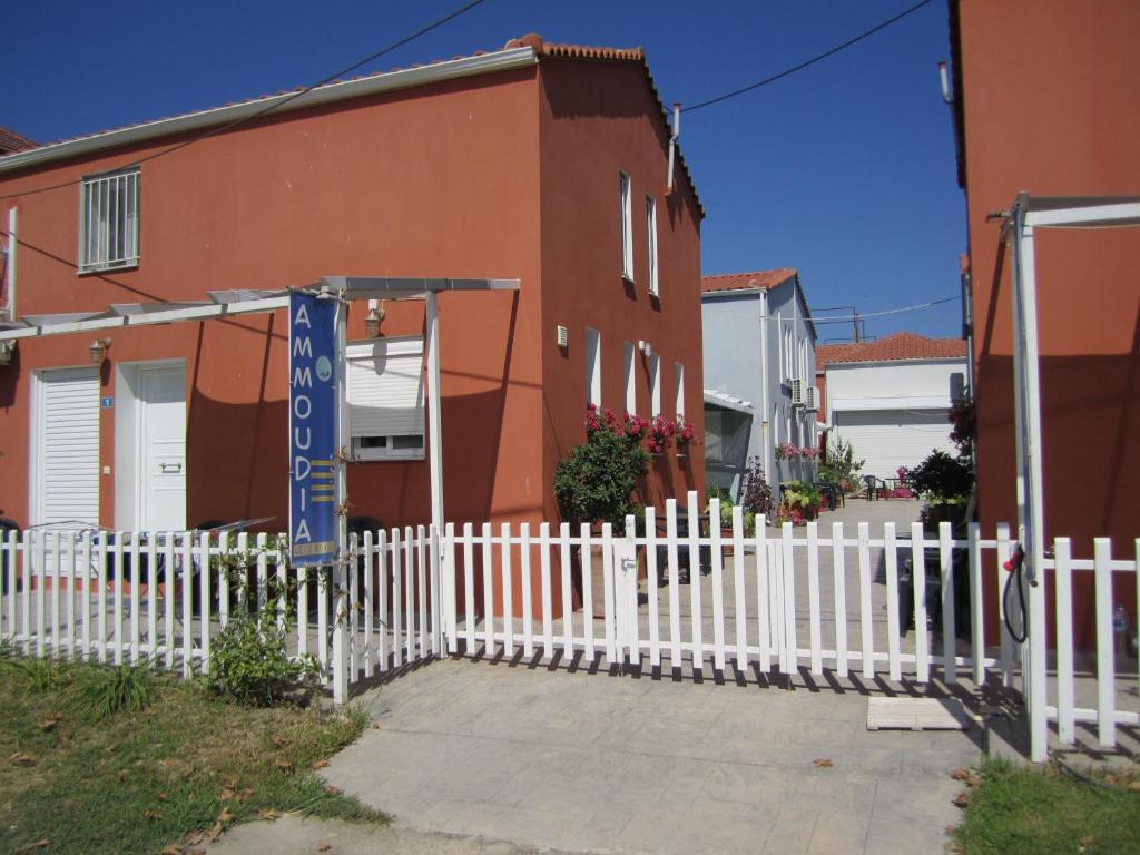a white picket fence in front of a house at Ammoudia Residence in Ammoudia