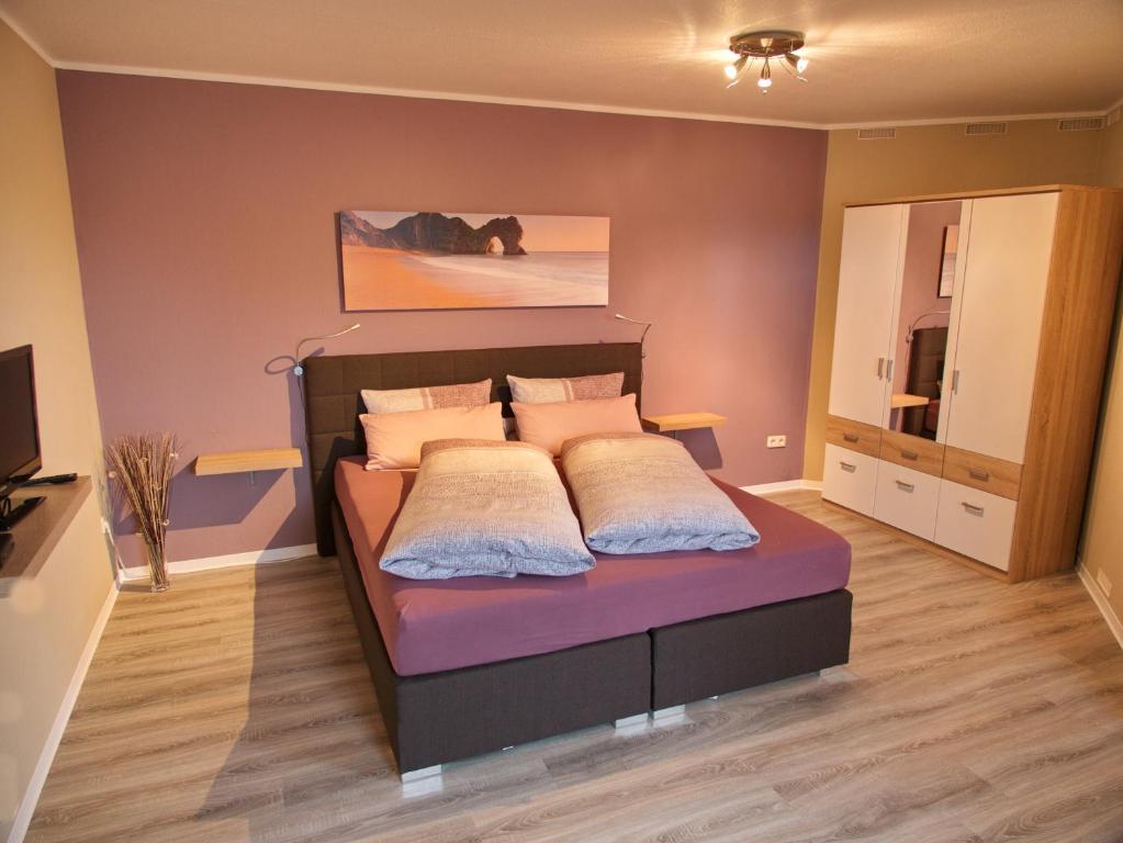 1 dormitorio con cama y espejo grande en Ferienwohnung Eggeblick, en Altenbeken
