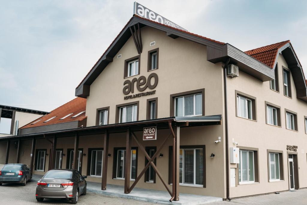 un gran edificio con coches estacionados frente a él en Areo Hotel & Restaurant en Odorheiu Secuiesc