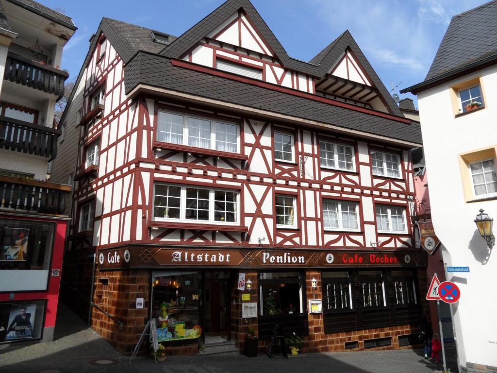 een rood-wit gebouw met een winkel bij Altstadt Hotel Cochem in Cochem