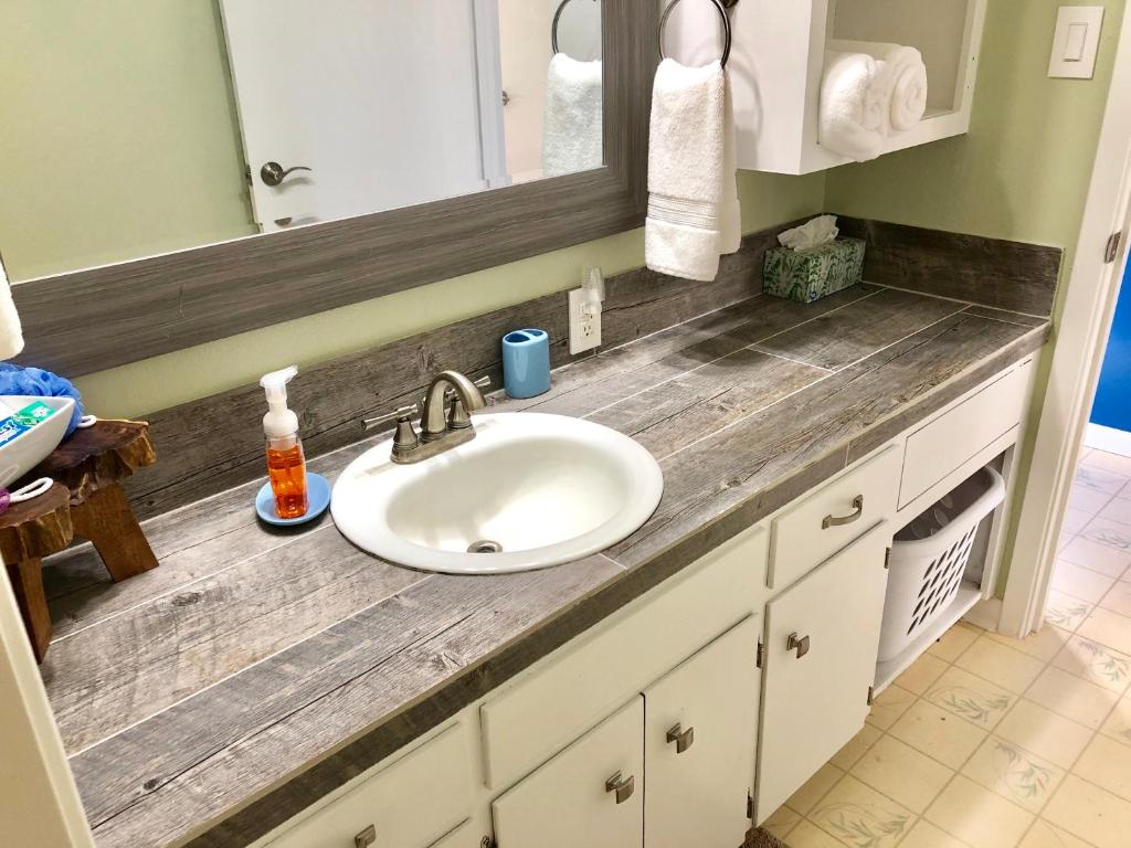 a bathroom counter with a sink and a mirror at Fishers Of Men Ranch Home in Marble Falls