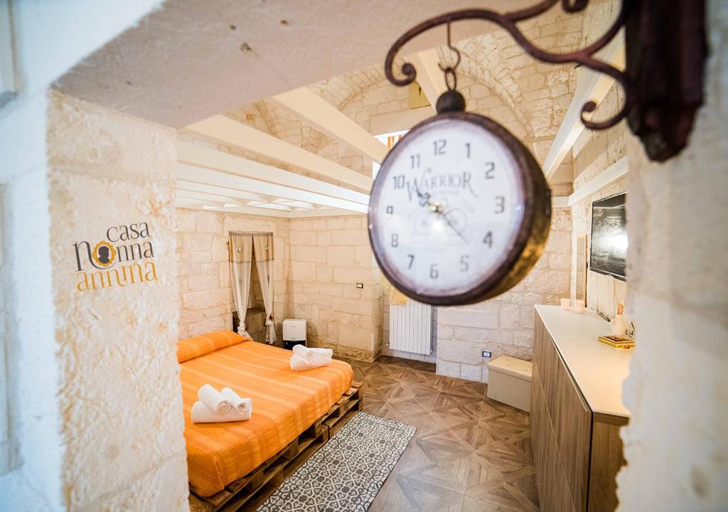 a bedroom with a bed and a clock on the wall at nonna annina in Martina Franca
