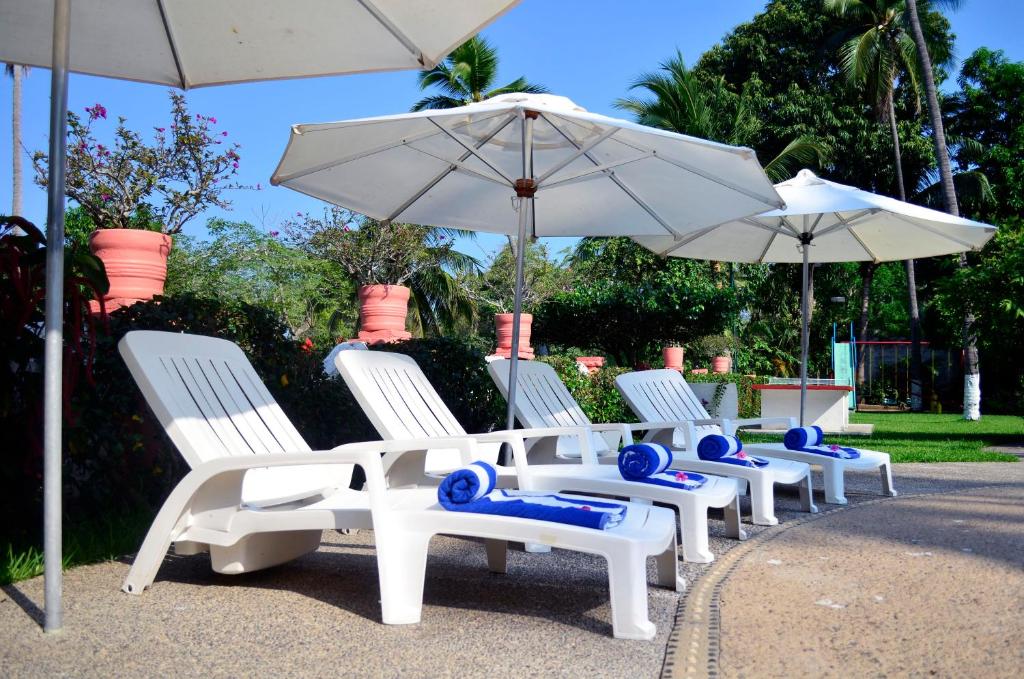 a row of white chairs and umbrellas at Coral Ixtapa in Ixtapa