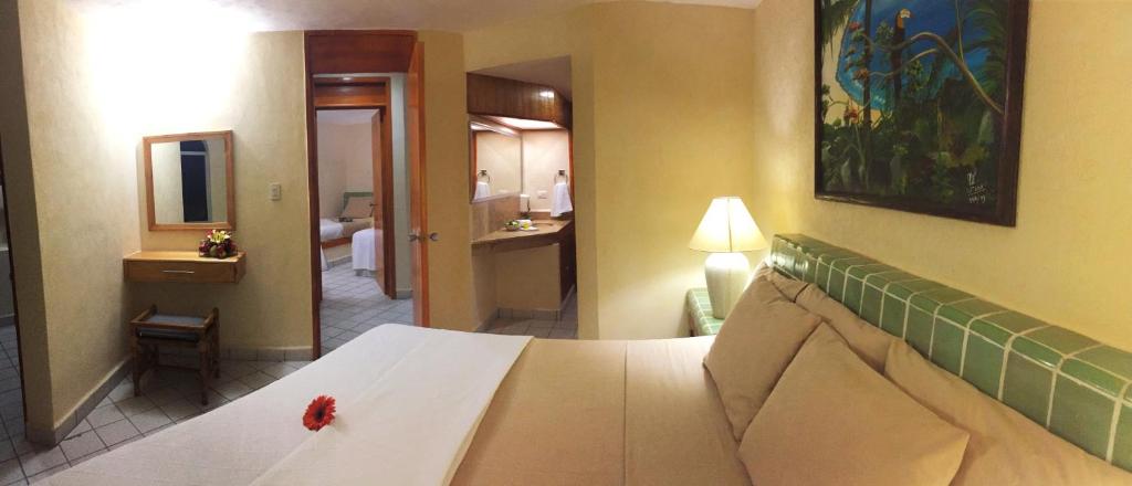 a bedroom with a bed and a room with a bathroom at Coral Ixtapa in Ixtapa