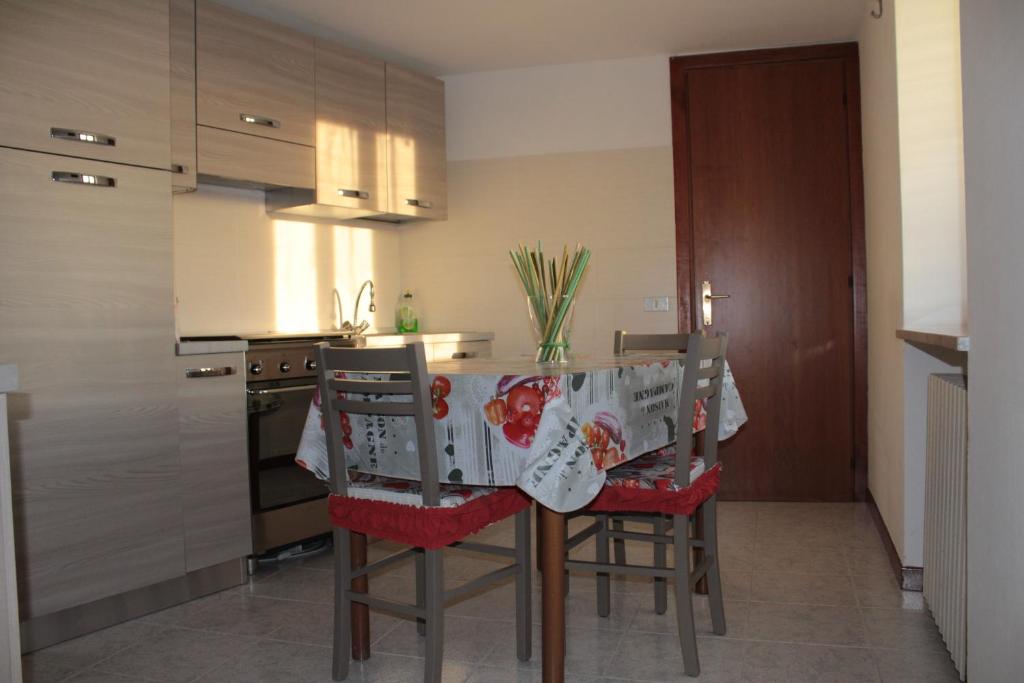 コステルマーノにあるAppartamento gialloのテーブルと椅子、テーブルクロス付きのキッチンが備わります。