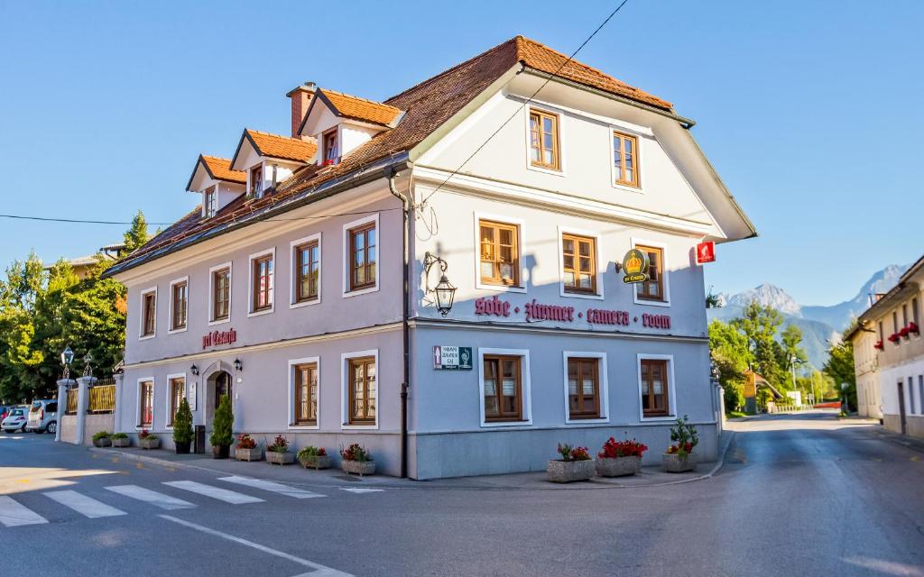 a large white building with a clock on the side of it at Guest House Pri Cesarju in Kamnik