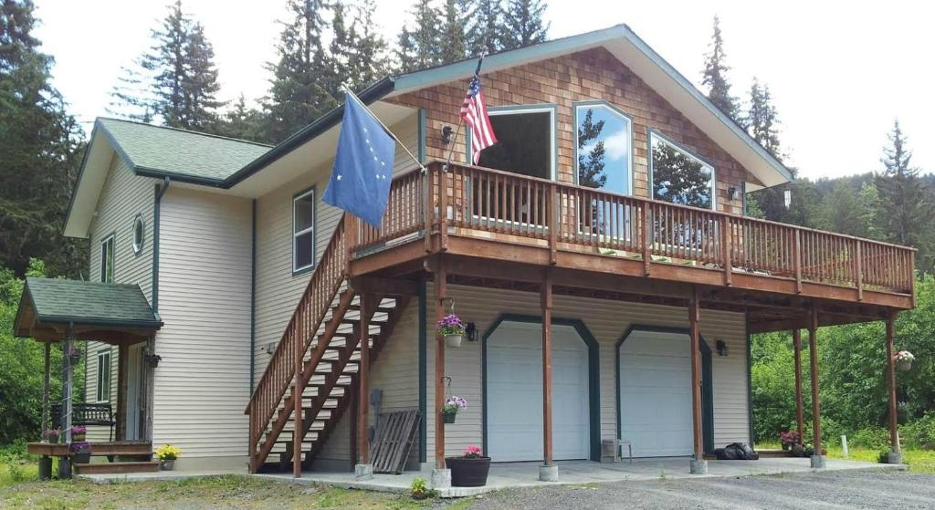 a house with a wrap around porch with a deck at Glacier Creek Lodging in Seward