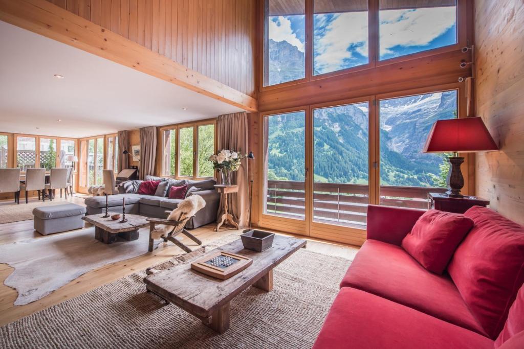 a living room with a red couch and a table at Luftschloss in Grindelwald