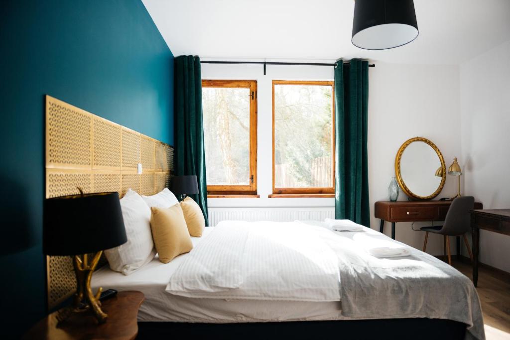 a bedroom with a bed with blue walls and a window at Villa Lulu Piaseczno in Piaseczno