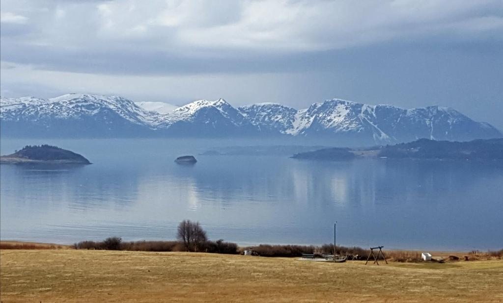 a view of a large body of water with snow covered mountains at Kjørsvik Øvre in Tornes