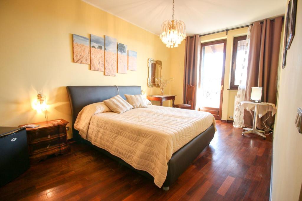 een slaapkamer met een bed en een kroonluchter bij Spighe Paglia e Girasole in Candia Canavese