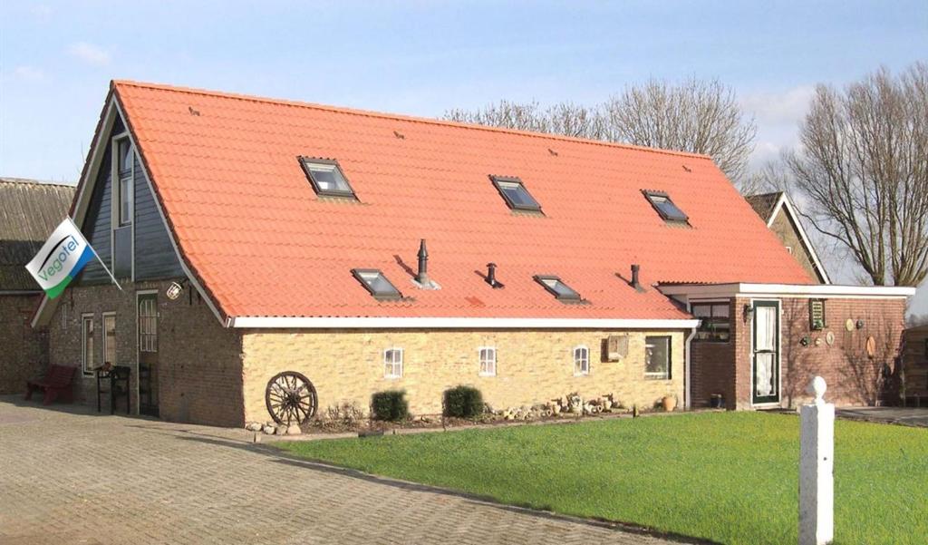 a large brick building with an orange roof at Vegotel in Blije