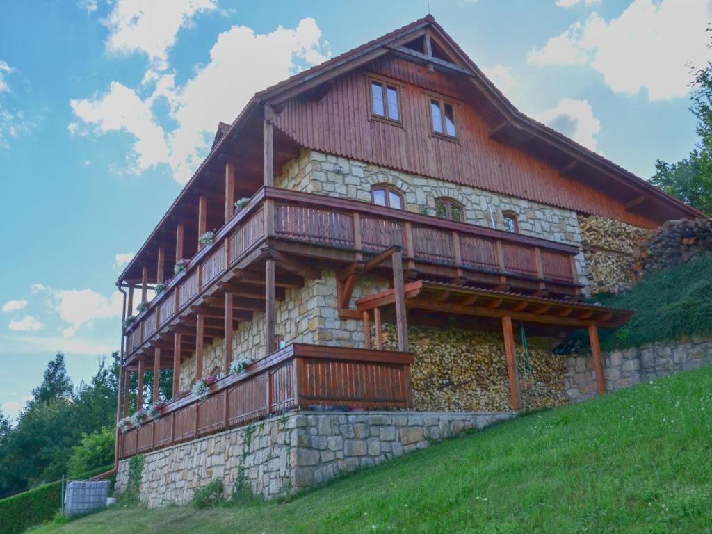 un gran edificio con techo de madera en una colina en Roubenka, en Červený Kostelec