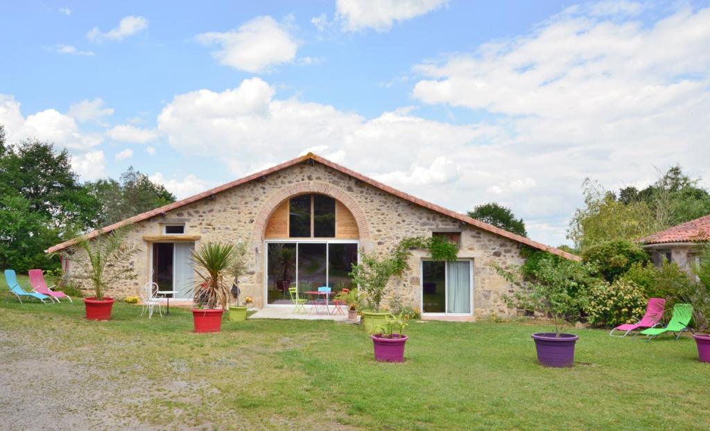 een stenen huis met potplanten in de tuin bij La Frapperie in La Pommeraie-sur-Sèvre