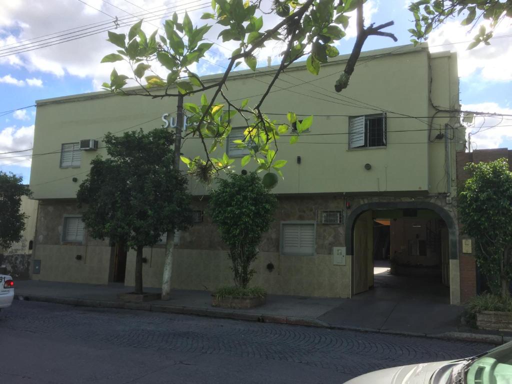 a green building with an archway in front of it at Hotel Suipacha in San Miguel de Tucumán