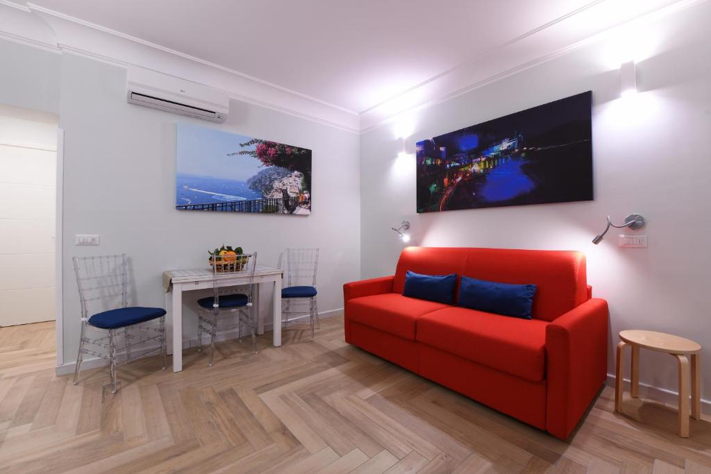 - un salon avec un canapé rouge et une table dans l'établissement Angela House Amalfi centro, à Amalfi