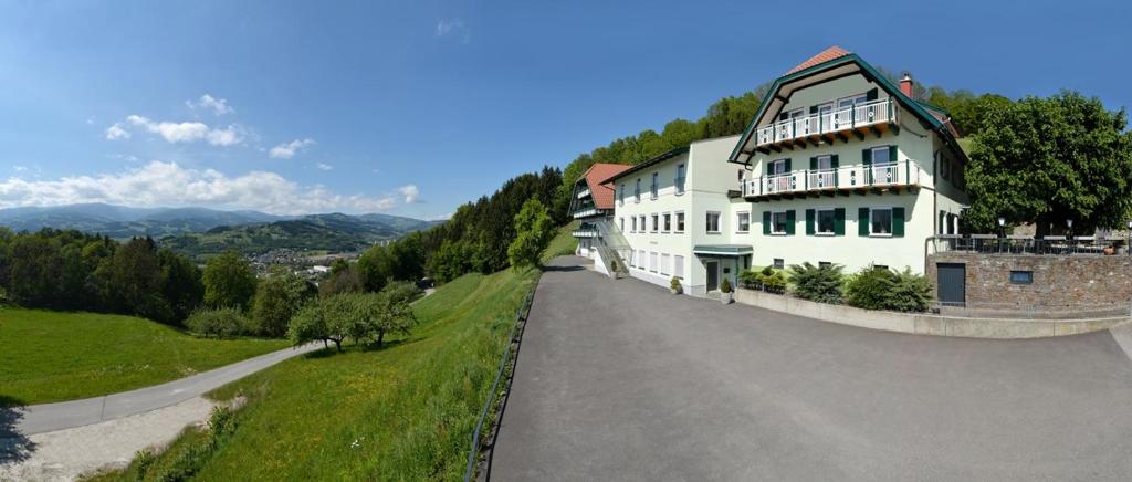 un grande edificio bianco sul lato di una strada di Gasthof-Pension Ölberger a Wolfsberg