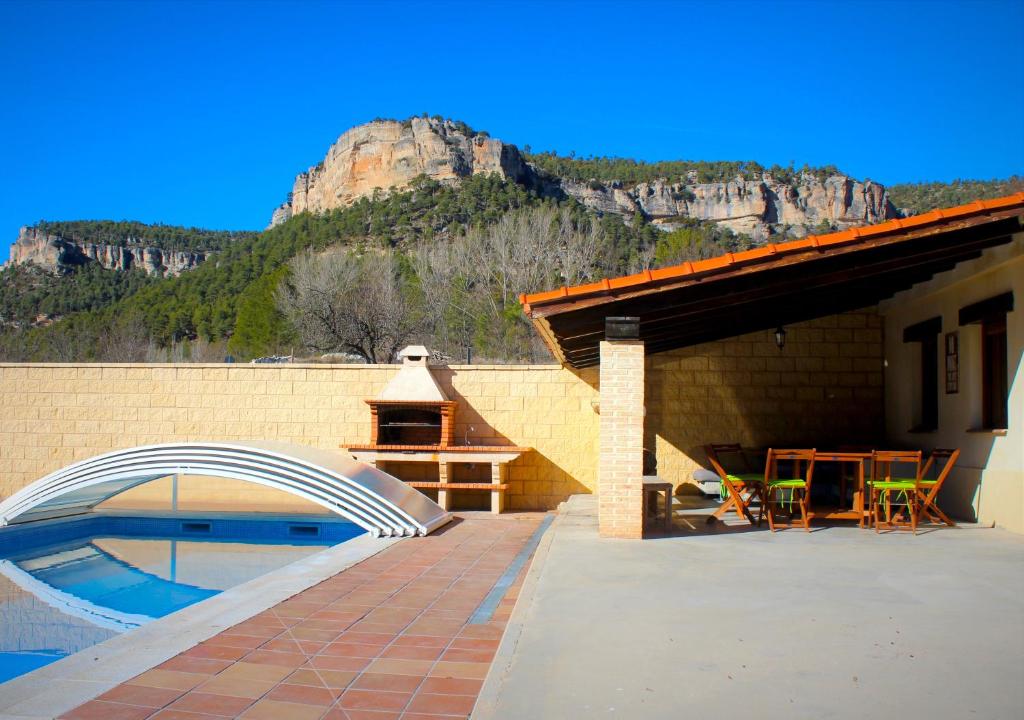 una casa con una piscina con una montaña en el fondo en Casa rural Laguna de Uña, en Uña