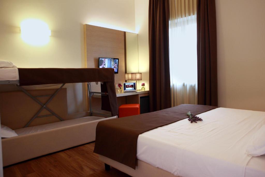 Pokój hotelowy z łóżkiem i łóżkiem piętrowym w obiekcie Hotel Colonne w mieście San Giovanni Rotondo