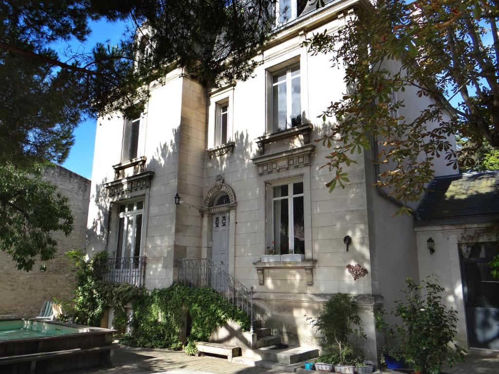 une grande maison blanche avec une piscine en face de celle-ci dans l'établissement Chambres d'hôtes Le Clos Bleu, à La Rochelle