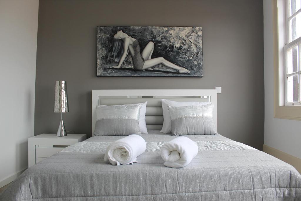 um quarto com uma cama com toalhas brancas em University View Flat em Coimbra