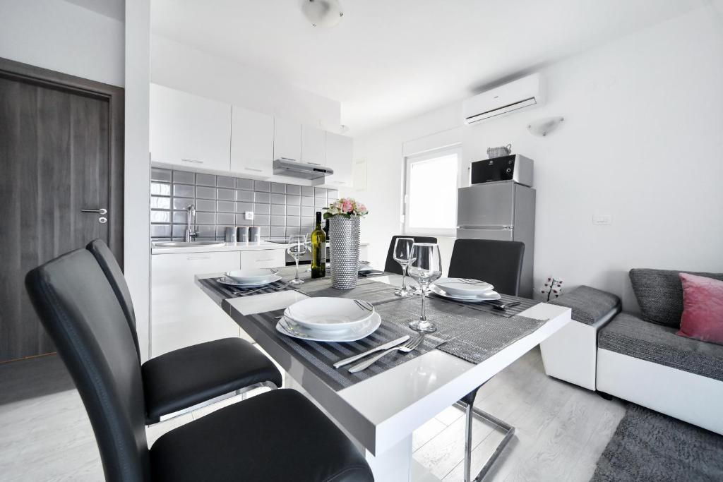 een keuken en eetkamer met een tafel en stoelen bij Deluxe Apartments Franić in Sukošan