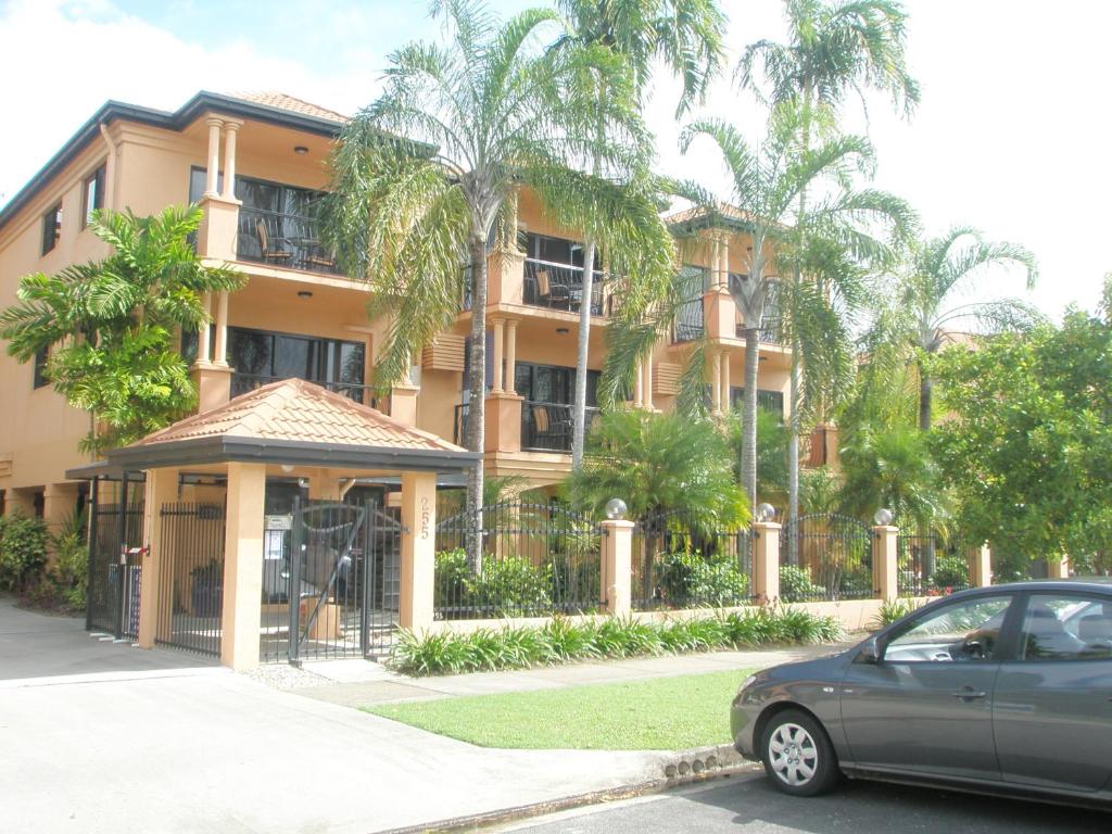a car parked in front of a building with palm trees at Central Plaza Apartments in Cairns