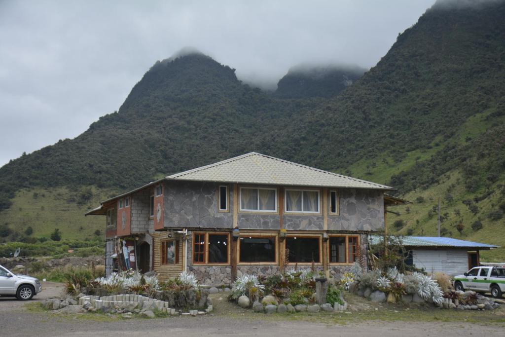a house in front of a mountain with a car at SOL DE PIEDRA in Papallacta