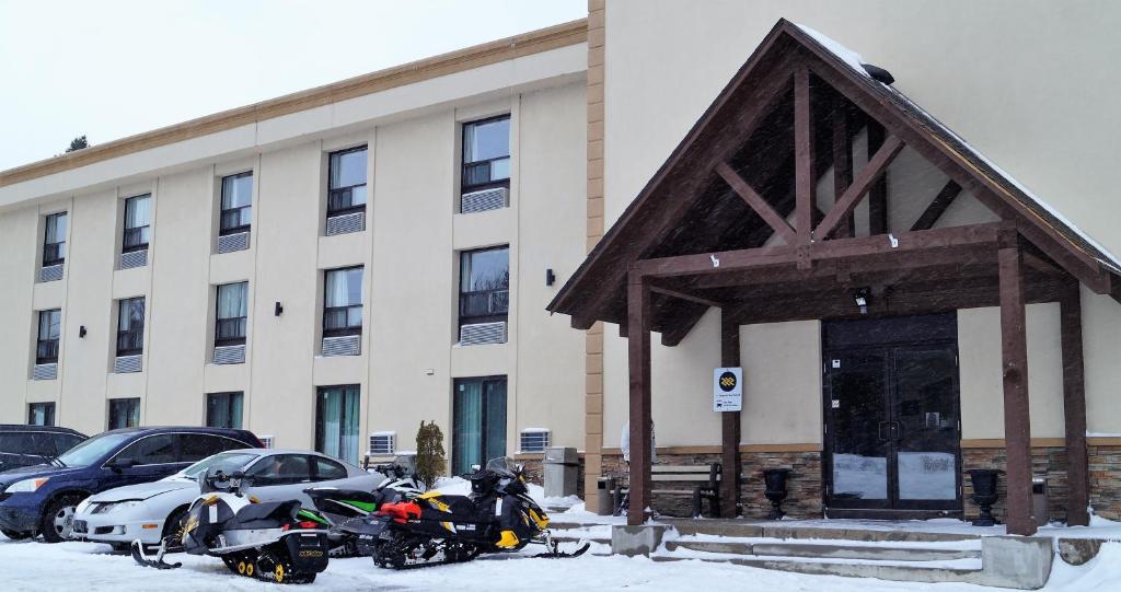 a parking lot filled with lots of snow next to a building at red maple inn and suites in Huntsville