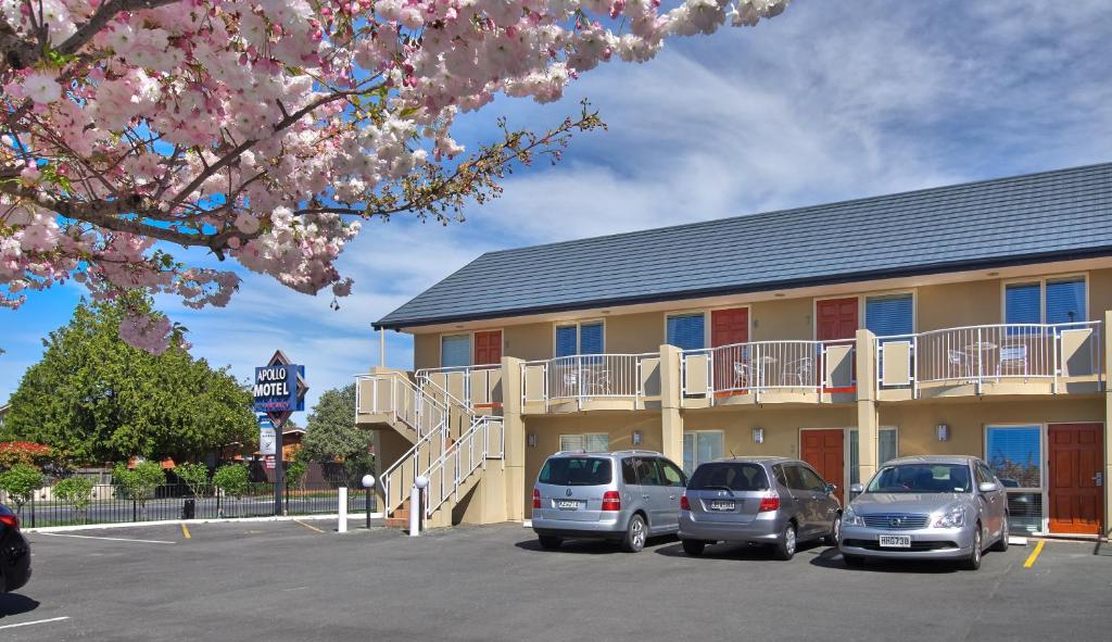 a building with cars parked in a parking lot at Apollo Motel in Christchurch