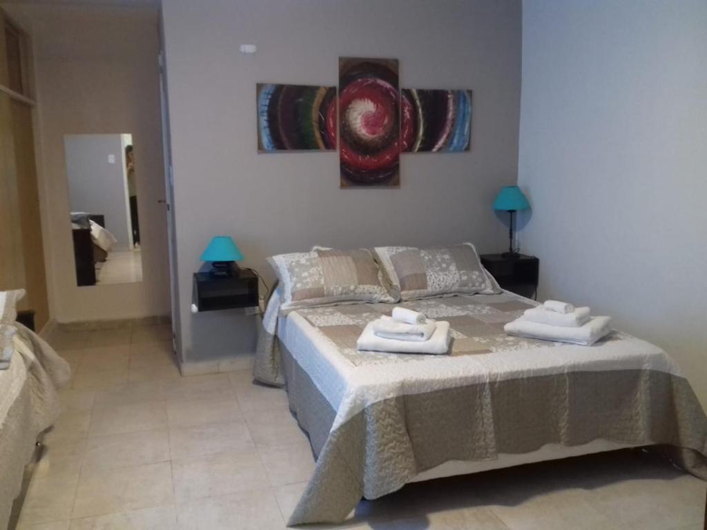 een slaapkamer met een bed met twee handdoeken erop bij EL DESCANSO DEPARTAMENTOS in Neuquén