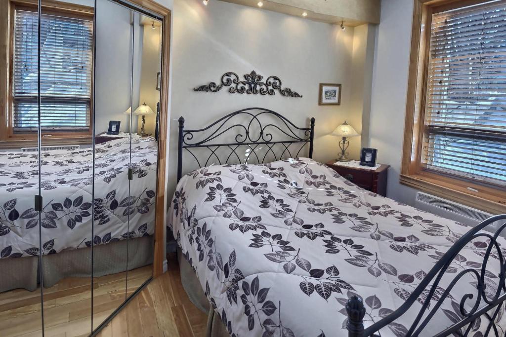 a bedroom with a black and white bed and a window at Gite Le Sieur de Joliette in Montréal