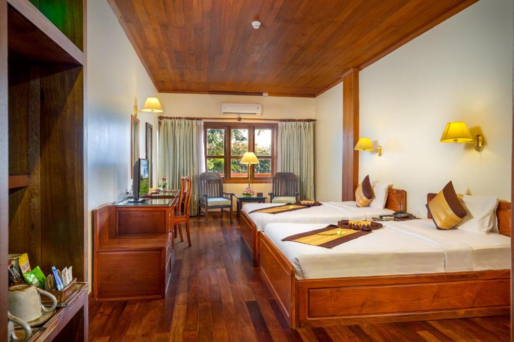 Postel nebo postele na pokoji v ubytování Ta Prohm Hotel & Spa