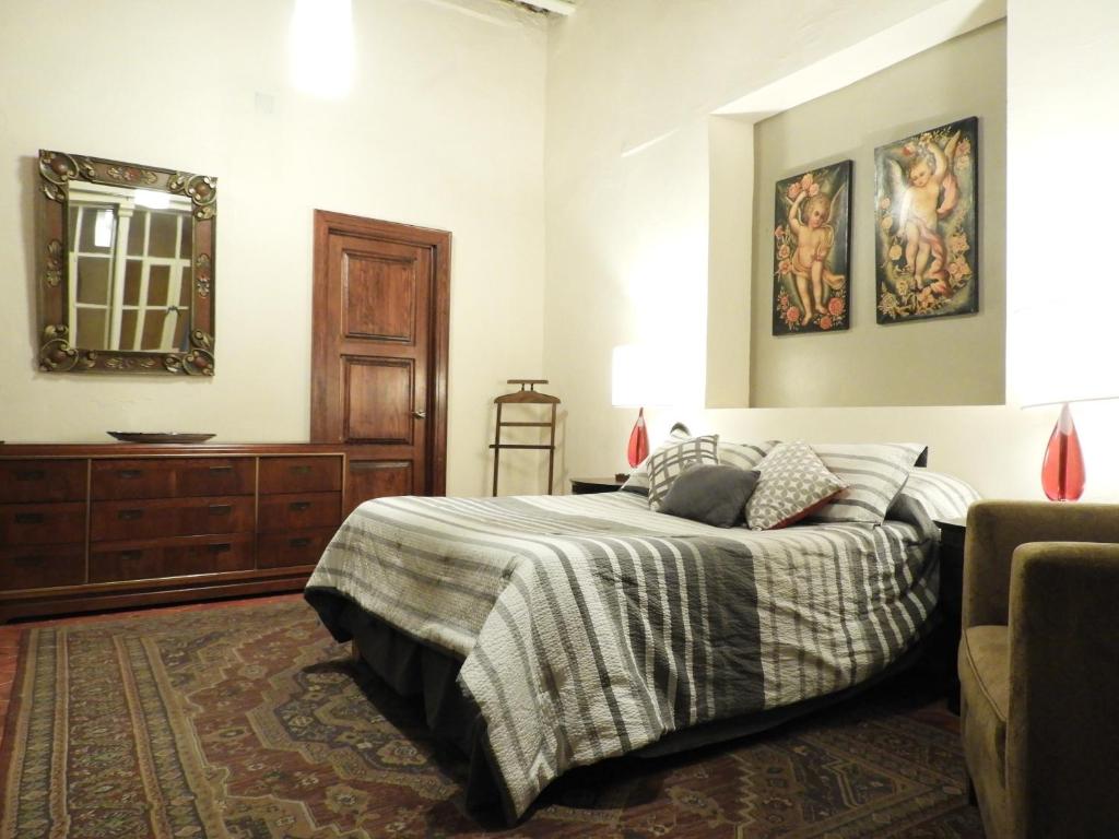 1 dormitorio con cama, espejo y tocador en El Viejo Zaguan by Lunian en Guanajuato